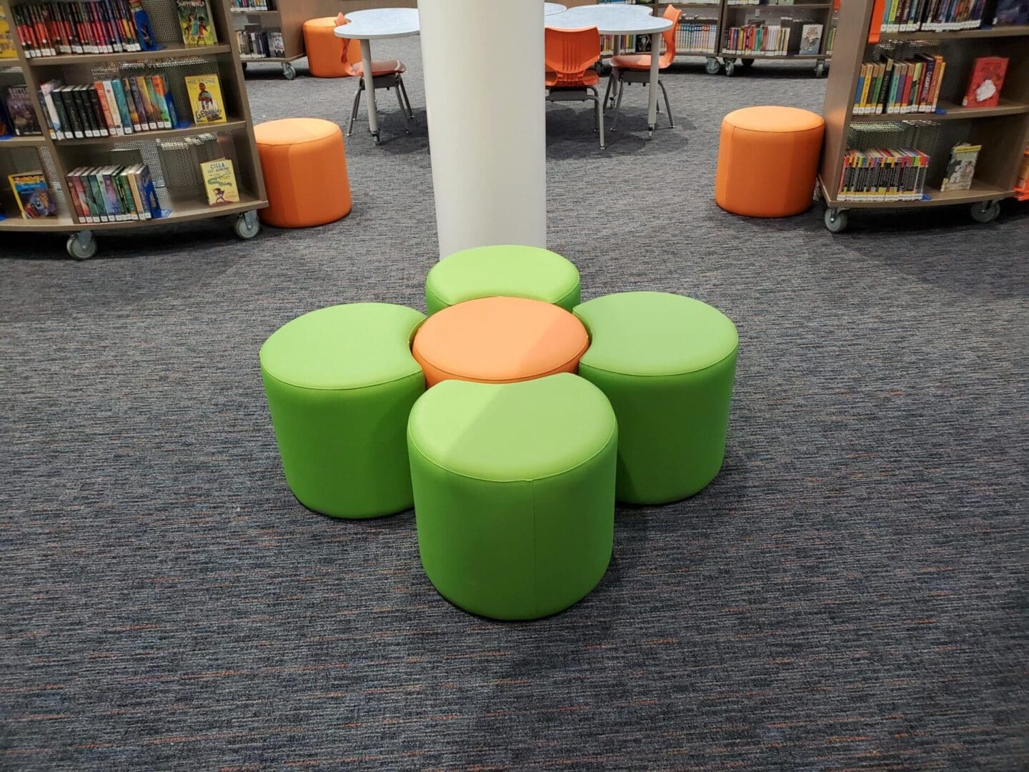 A room with several green and orange ottomans.