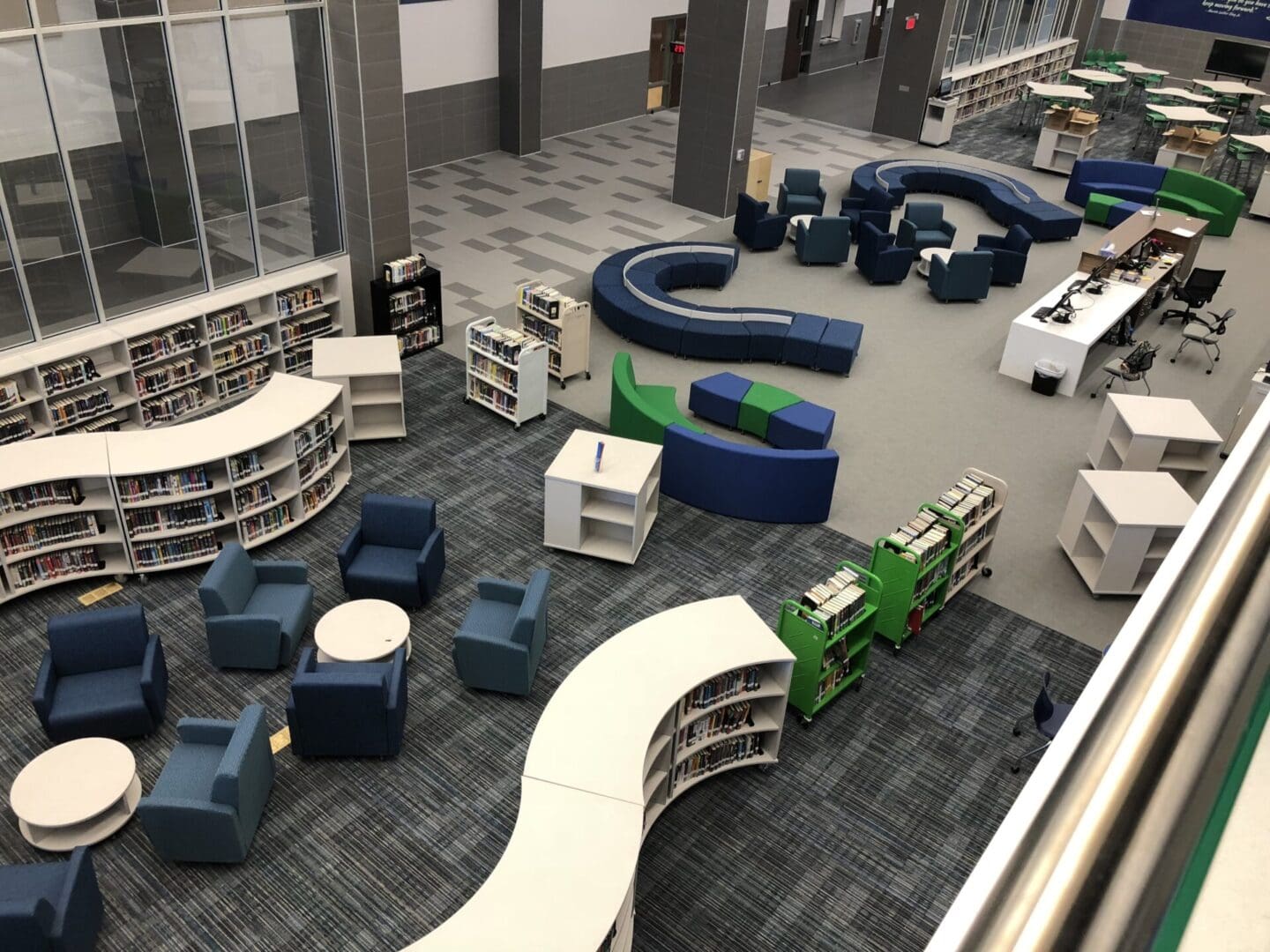 A library with many blue and green chairs.