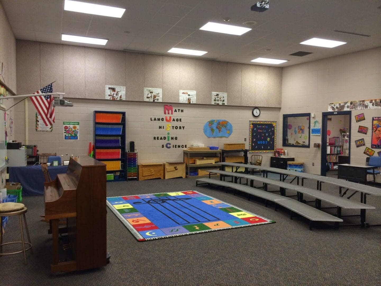 A classroom with many steps and a rug.