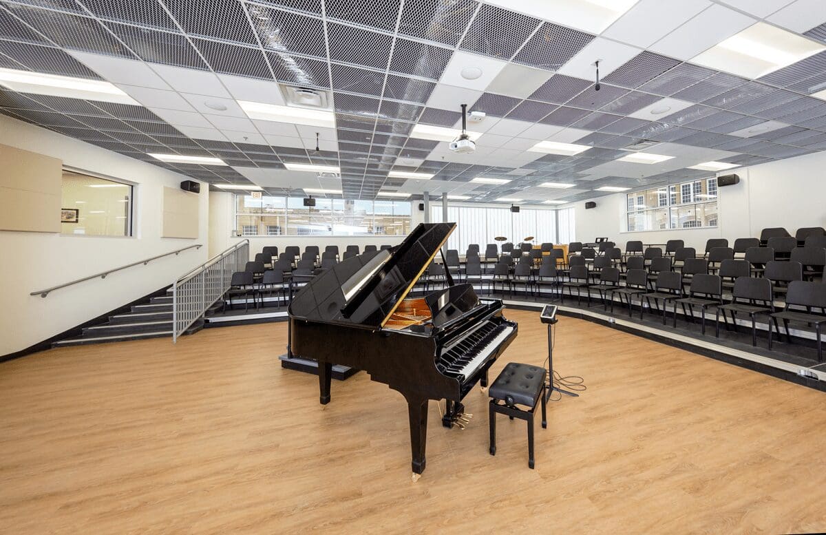 A piano in front of an auditorium with rows of seats.