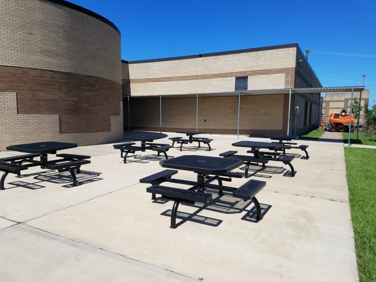 A group of picnic tables in the middle of an outdoor area.
