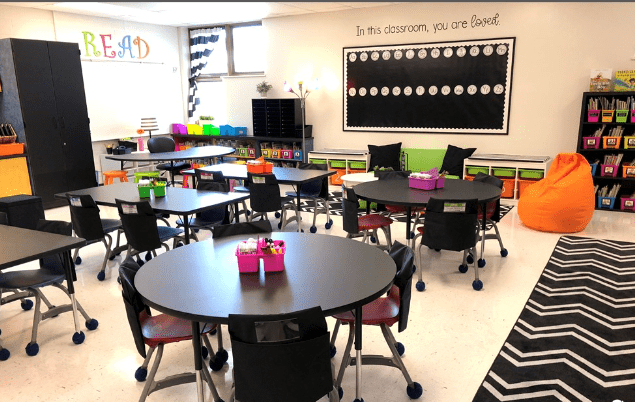 A classroom with tables and chairs in it