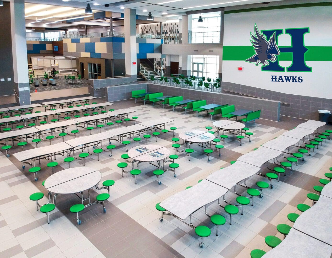 A large cafeteria with green seats and tables.
