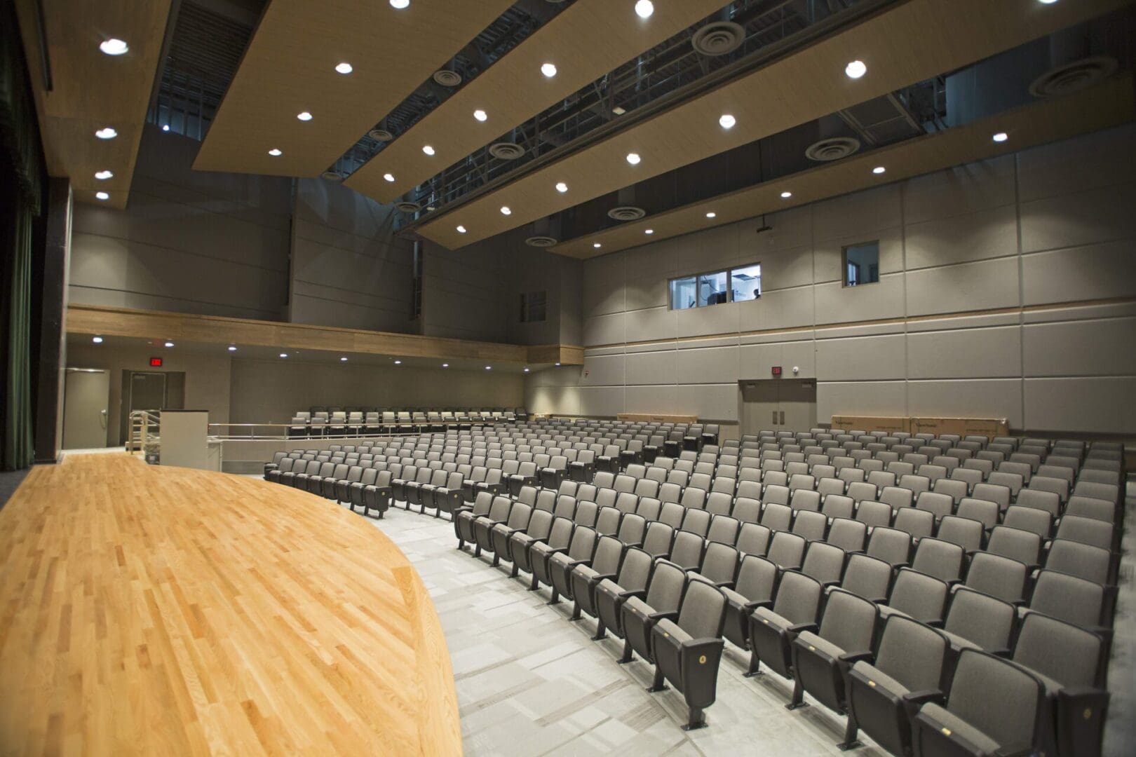 A large auditorium with many seats and tables.