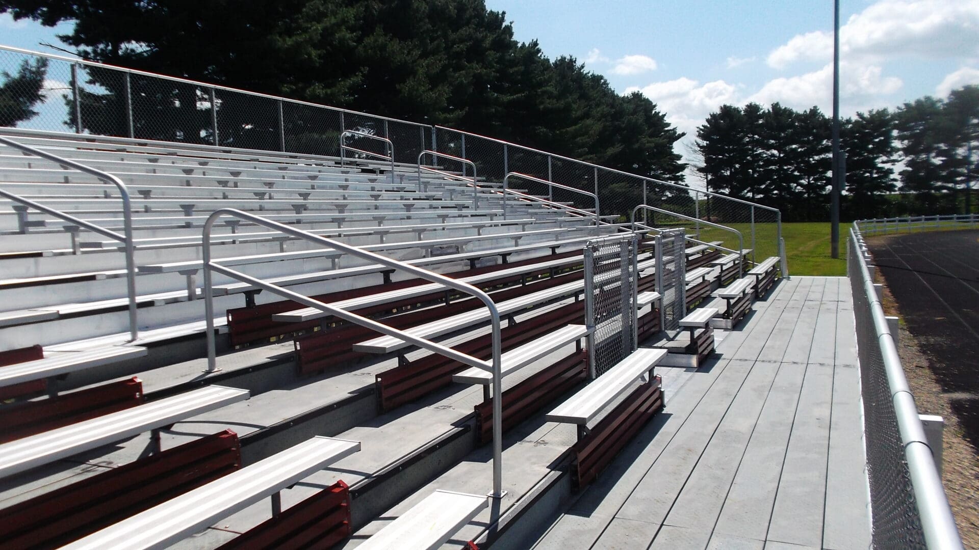 A bleacher with metal railing and seats