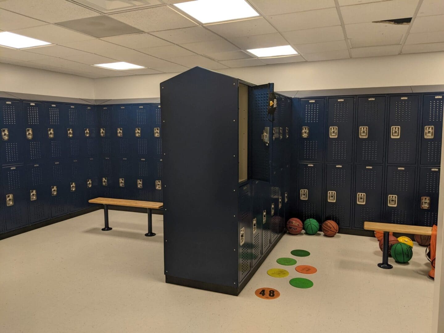 A room with many blue lockers and benches