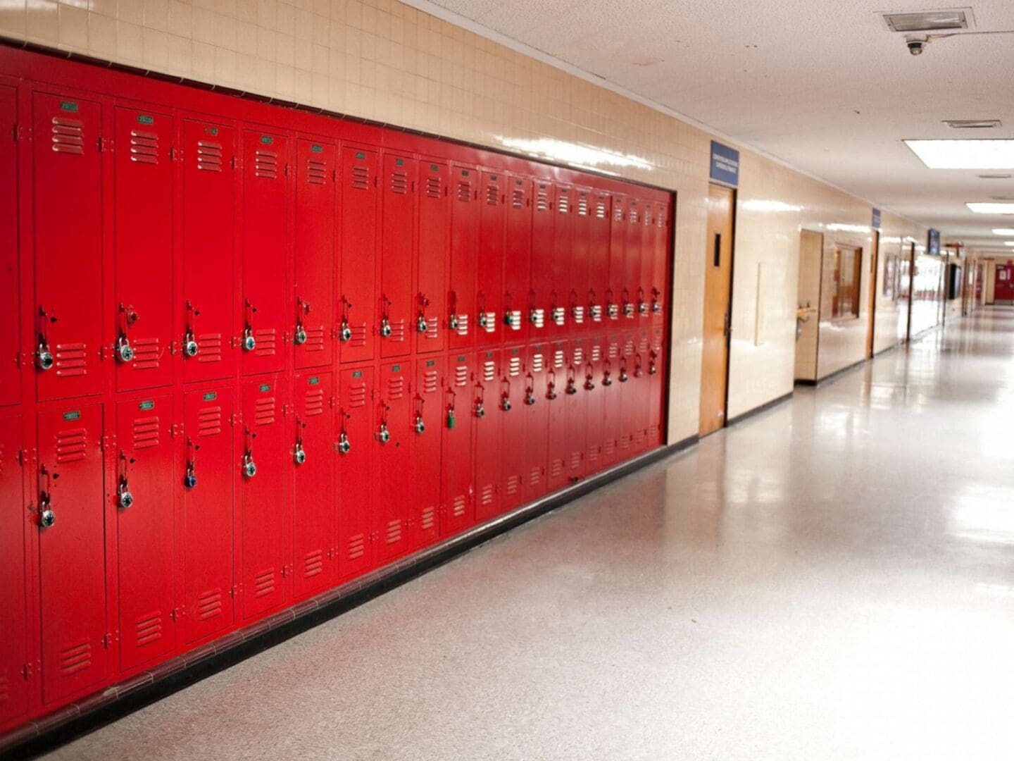 A hallway with red lockers and white walls.