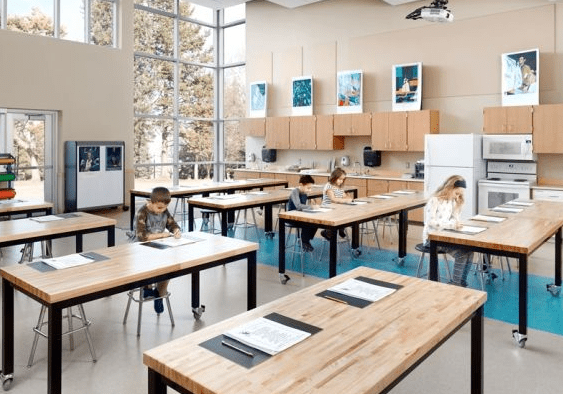 A classroom with desks and chairs, and students writing.