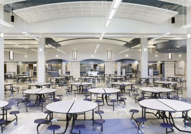 A large cafeteria with many tables and chairs.